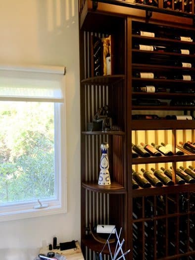 The Left Wall of This Traditional Home Wine Cellar Consists of a Curved Custom Wood Wine Rack